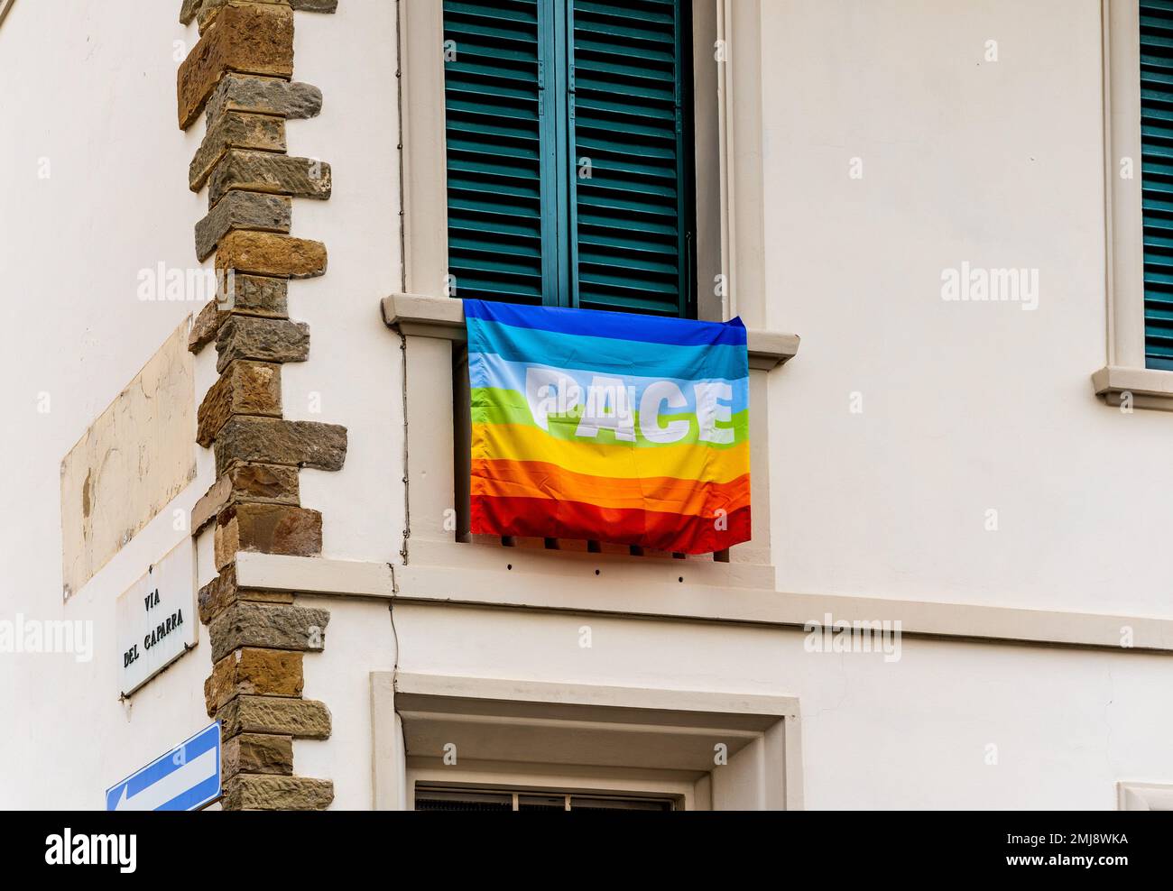 Un drapeau arc-en-ciel avec le mot italien « Pace » signifiant « Peace » écrit sur lui à une fenêtre dans le centre-ville de Florence, en Toscane, en Italie Banque D'Images