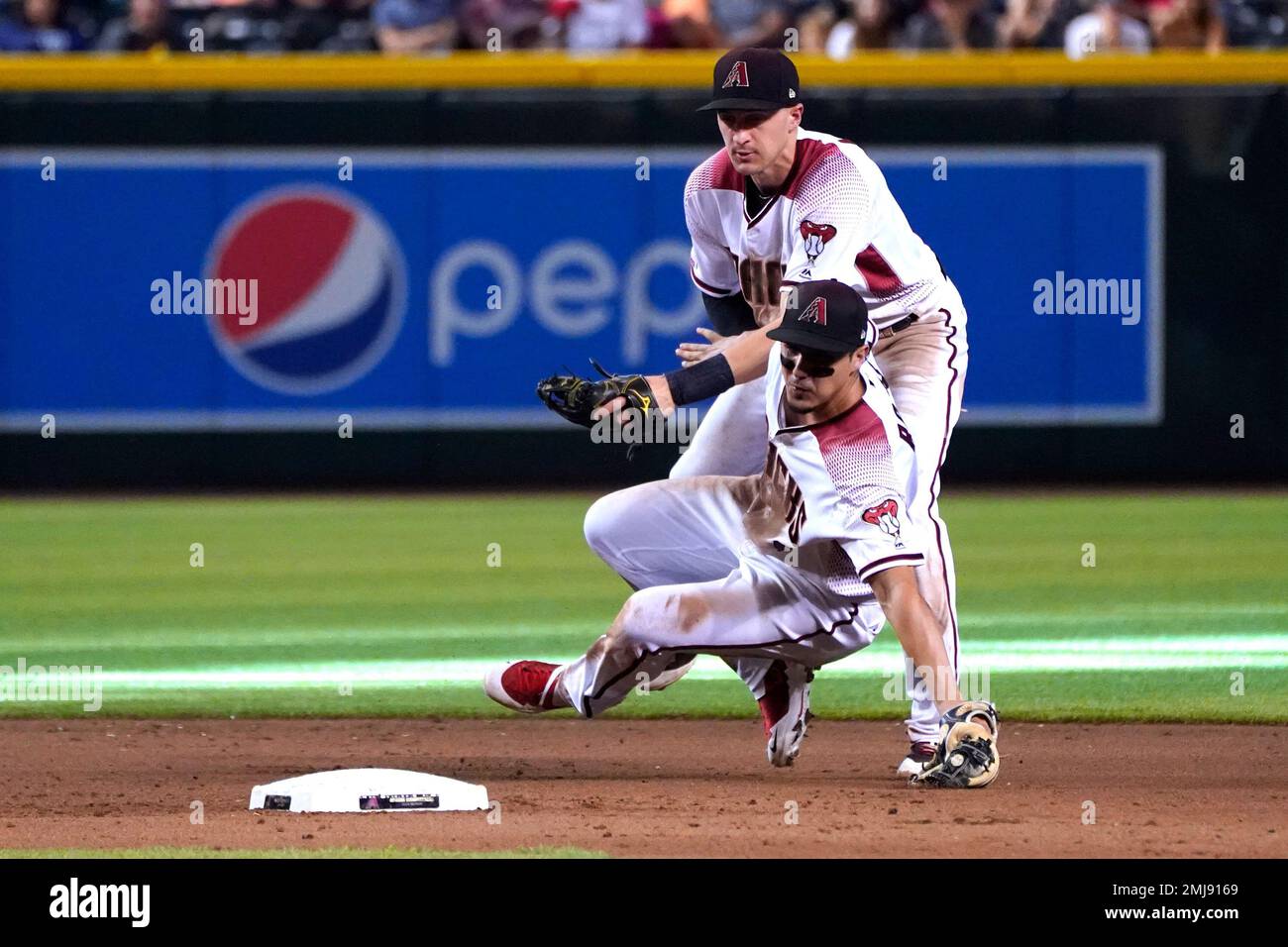 Arizona Diamondbacks shortstop Nick Ahmed, top, and Josh Rojas, bottom, collide on a ball hit by San Diego Padres' Ty France in the eighth inning of a baseball game, Monday, Sept. 2, 2019, in Phoenix. (AP Photo/Rick Scuteri) Banque D'Images