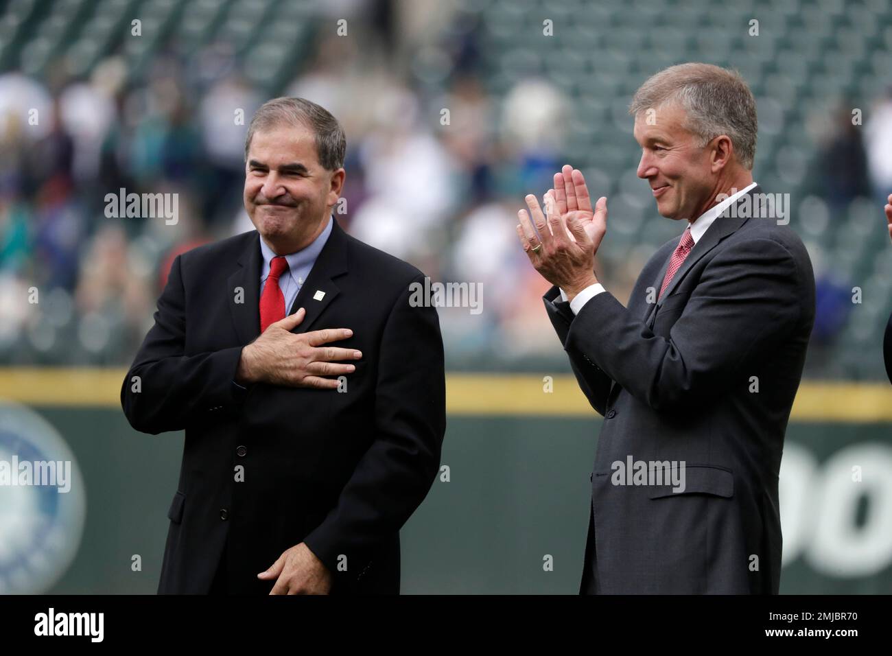 Tim Mead, left, president of the National Baseball Hall of Fame and Museum, motions while being introduced as Kevin Mather, Seattle Mariners president and CEO, applauds during a ceremony honoring former Seattle Mariners designated hitter Edgar Martinez for his recent induction into the Baseball Hall of Fame before a baseball game between the Mariners and Tampa Bay Rays Saturday, Aug. 10, 2019, in Seattle. (AP Photo/Elaine Thompson) Banque D'Images