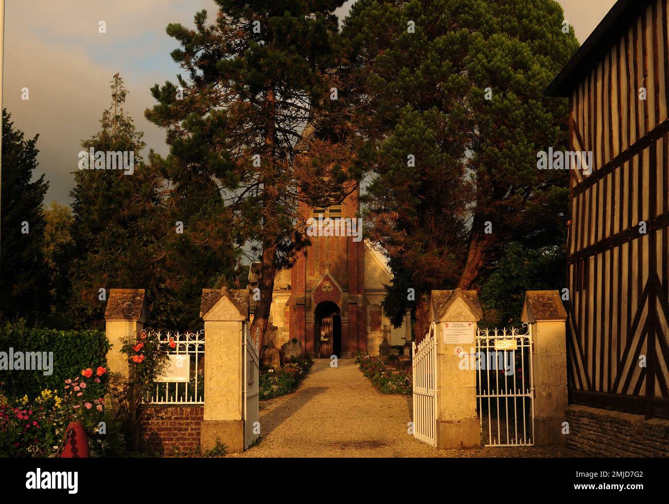 Église Saint-Martin de Beuvron-en-Auge baignée par la lumière du soleil de la fin de l'après-midi en Normandie, en France, lors D'Une belle Journée d'été ensoleillée avec quelques nuages en T Banque D'Images