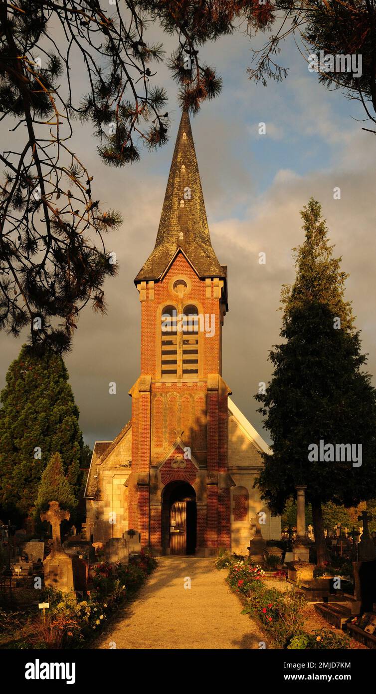 Église Saint-Martin de Beuvron-en-Auge baignée par la lumière du soleil de la fin de l'après-midi en Normandie, en France, lors D'Une belle Journée d'été ensoleillée avec quelques nuages en T Banque D'Images
