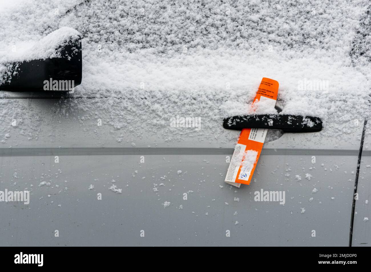 Chicago, il, Etats-Unis - 27 janvier 2023: Ville de Chicago avis de violation de stationnement à l'intérieur de la poignée de porte d'une voiture au début d'une tempête de neige. Banque D'Images