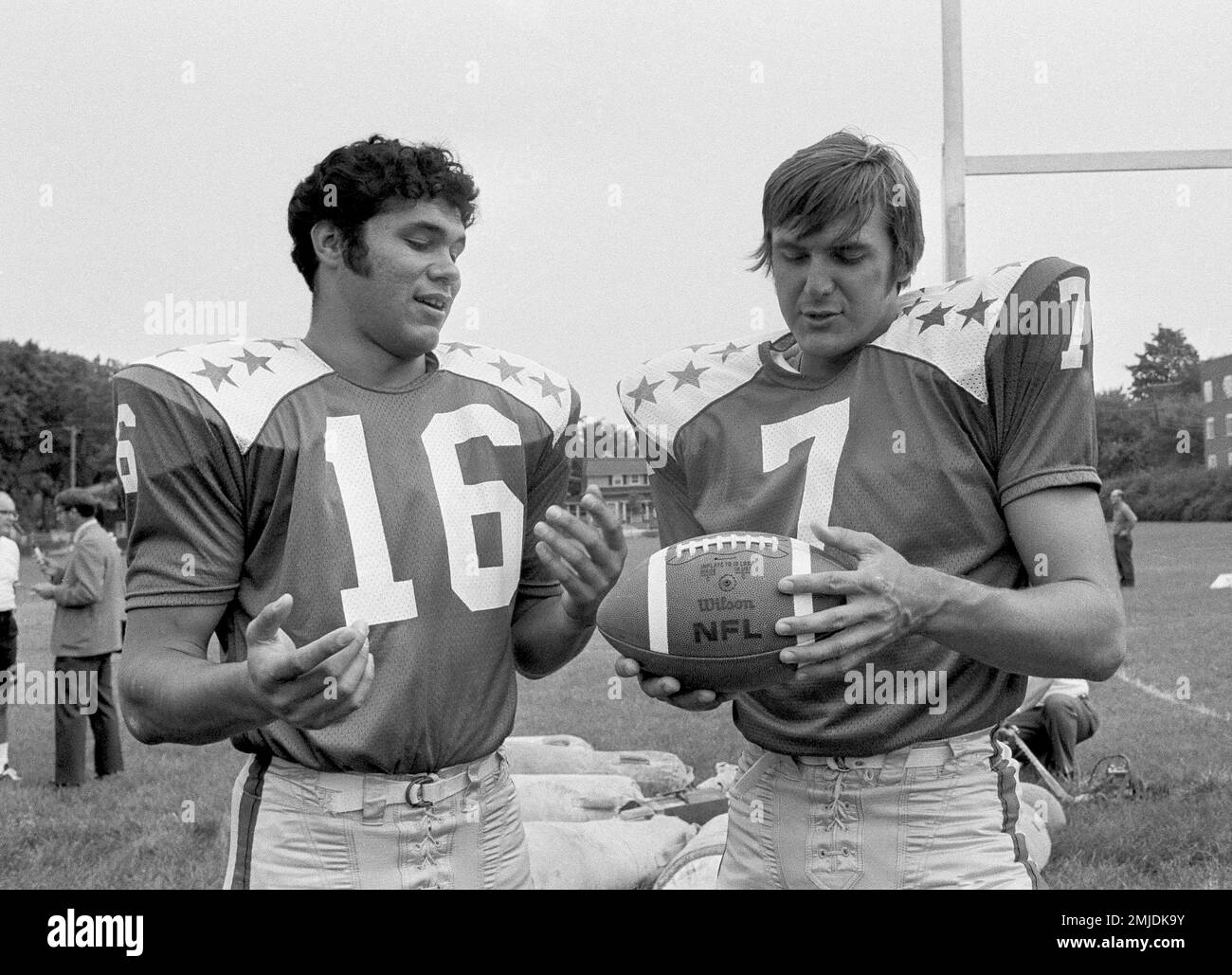 FILE - In this July 9, 1971, file photo, College All-Star quarterbacks Jim Plunkett (16) and Dan Pastorini (7) talk at practice in Evanston, Ill., for a charity game against the Baltimore Colts to be played July 30, 1971, in Chicago. In the early days of the NFL, college football was king and playing the game professionally was not necessarily something players aspired to do. By planting its flag in large cities, embracing television exposure and playing a more entertaining style, the NFL surged in popularity in the middle of the 20th century and helped turn college football into a means to an Banque D'Images