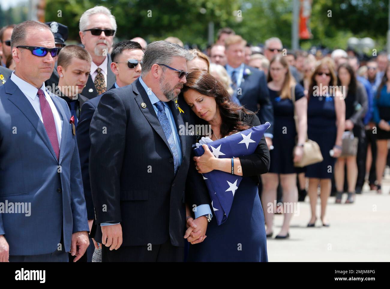 Kelley O' Sullivan leans her head on there shoulder of her husband, Denis, as she holds the American flag that had covered the casket of her daughter, Sacramento Police Officer Tara O'Sullivan, during memorial services at the Bayside Adventure Church in Roseville, Calif., Thursday, June 27, 2019. Tara O'Sullivan was shot and killed last week responding to a domestic violence call. (AP Photo/Rich Pedroncelli) Banque D'Images
