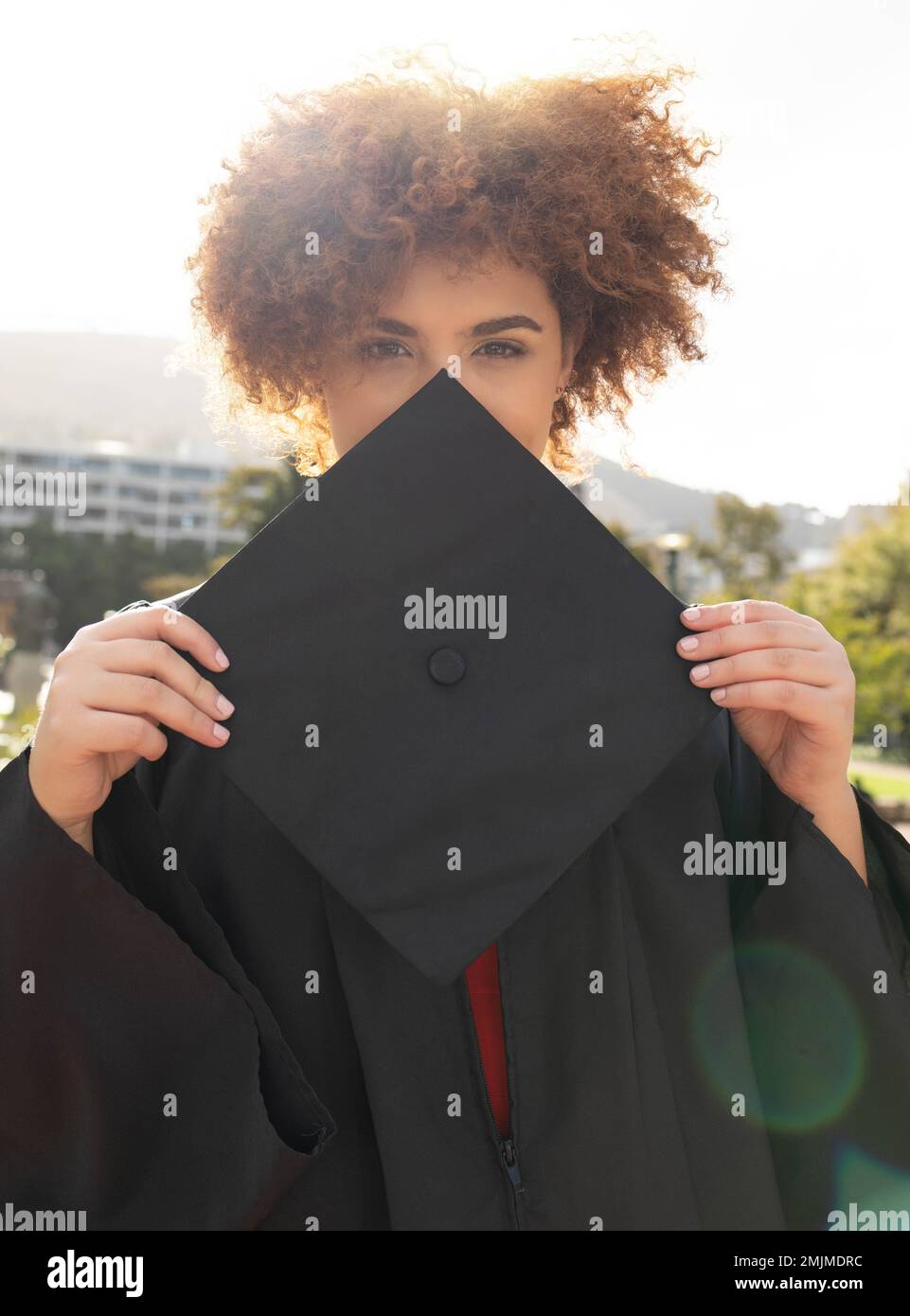 Une fille étudiante à l'université, un portrait et un chapeau de graduation pour cacher le visage avec succès, réalisation et but. Femme noire, célébration de troisième cycle et vision dans Banque D'Images