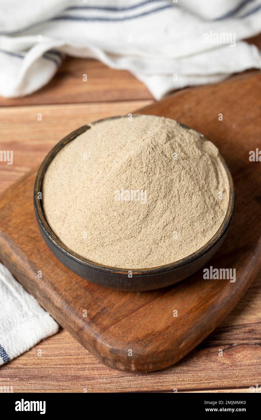 Piment blanc en poudre. Grains de poivre blanc moulu en poudre dans un bol sur fond de bois. Concept d'épices sèches. gros plan Banque D'Images