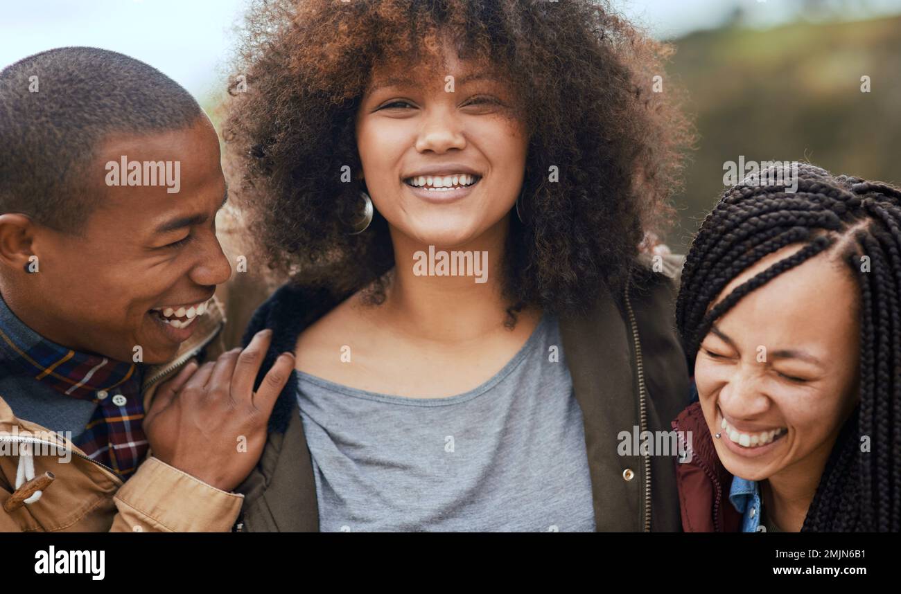Les amis rendent les moments heureux encore plus heureux. Portrait d'un groupe d'amis heureux se posant ensemble à l'extérieur. Banque D'Images
