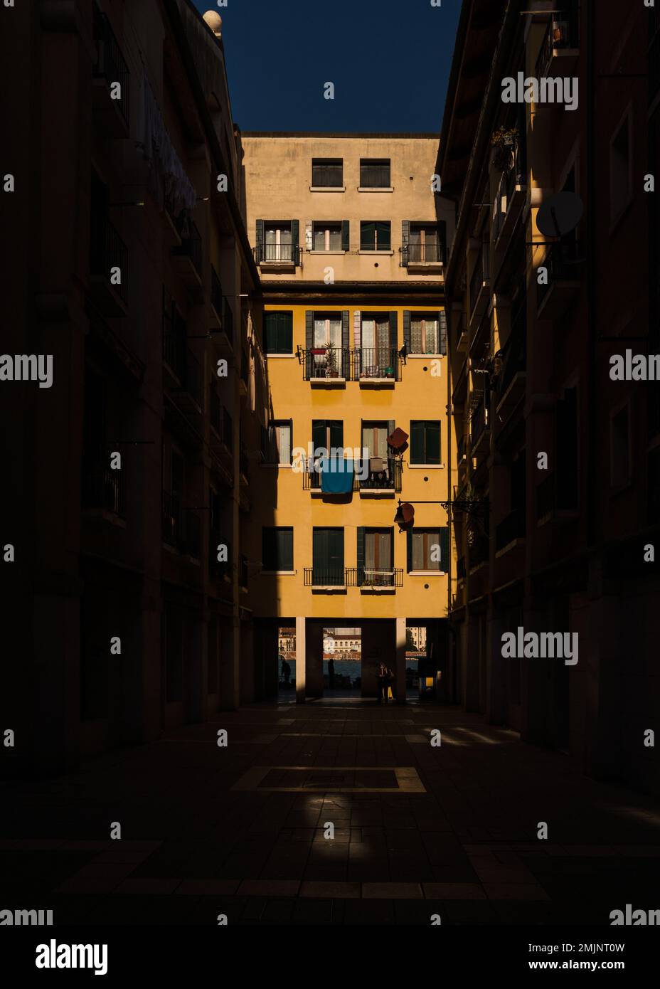 Immeuble d'appartements jaune à Venise, Italie avec contraste élevé d'éclairage Banque D'Images