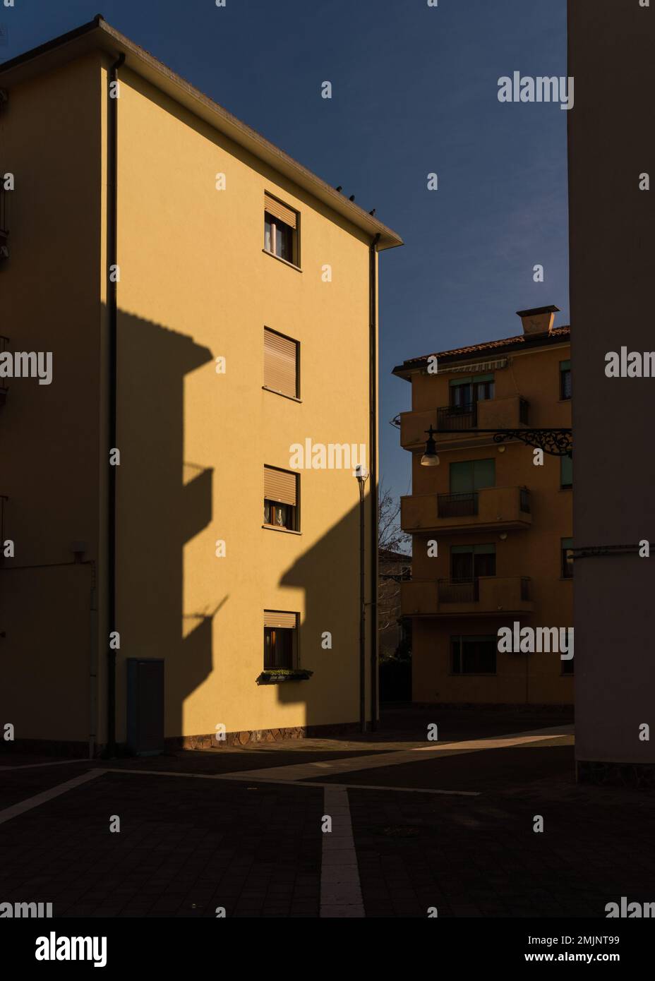Immeuble d'appartements jaune à Venise, Italie avec contraste élevé d'éclairage Banque D'Images