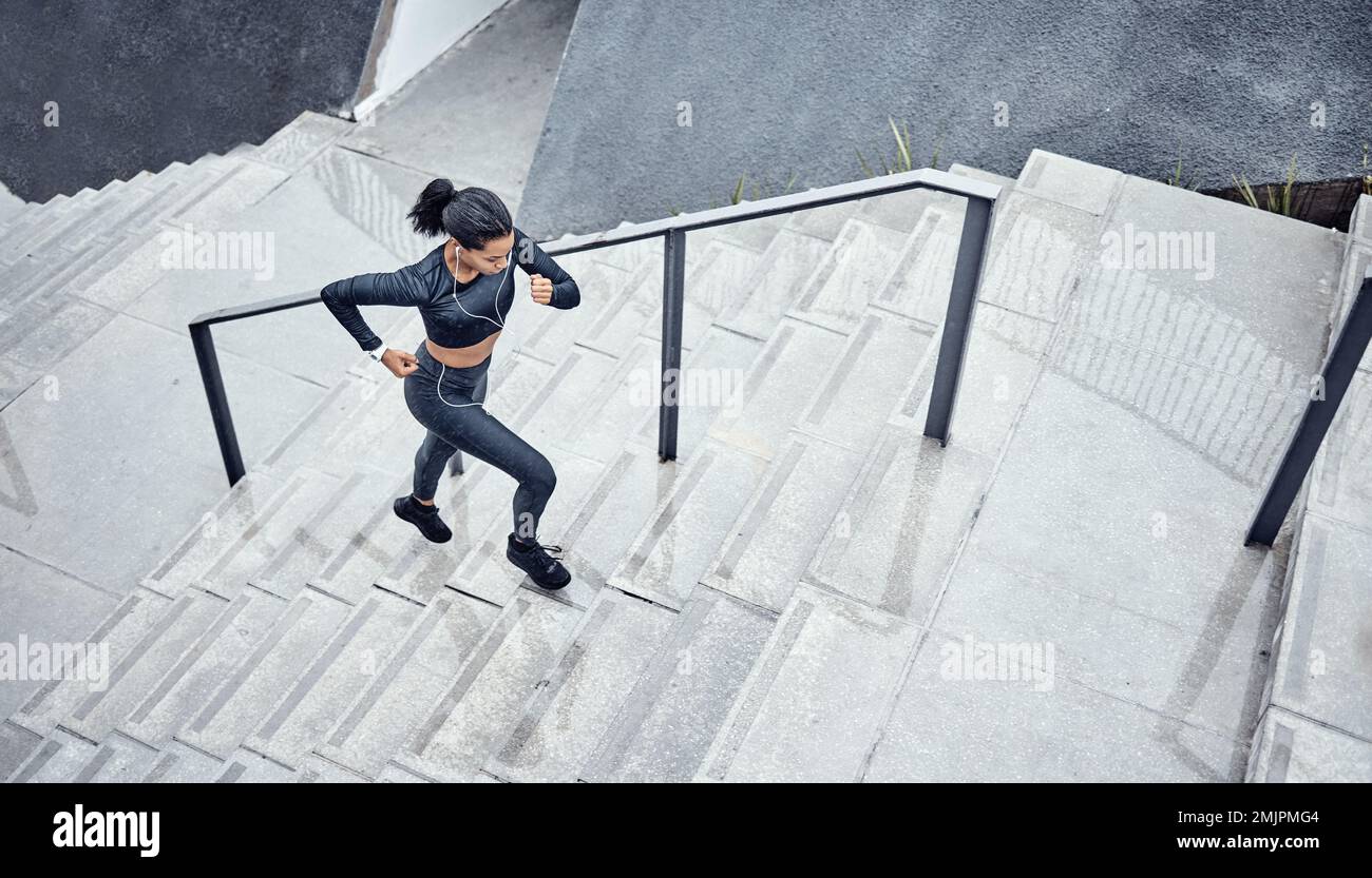 Entraînement, au-dessus et femme courir sur les escaliers pour le pouvoir, le sport et l'énergie du corps dans la ville. Défiez, entraînez-vous et entraînez-vous avec un coureur cardio sur les marches Banque D'Images