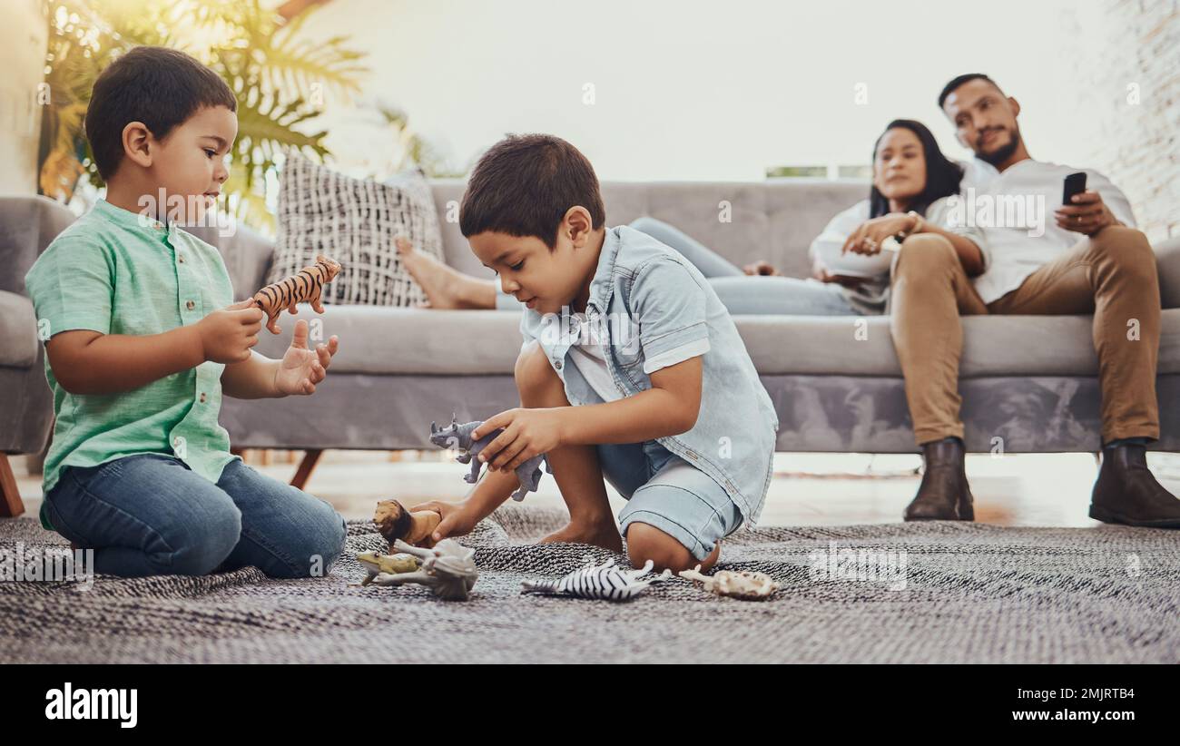 Les dinosaures, la famille ou les enfants jouent avec des jouets pour la croissance du développement avec la mère et le père relaxant regarder la télévision. Éducation, frères et sœurs ou jeunes garçons Banque D'Images