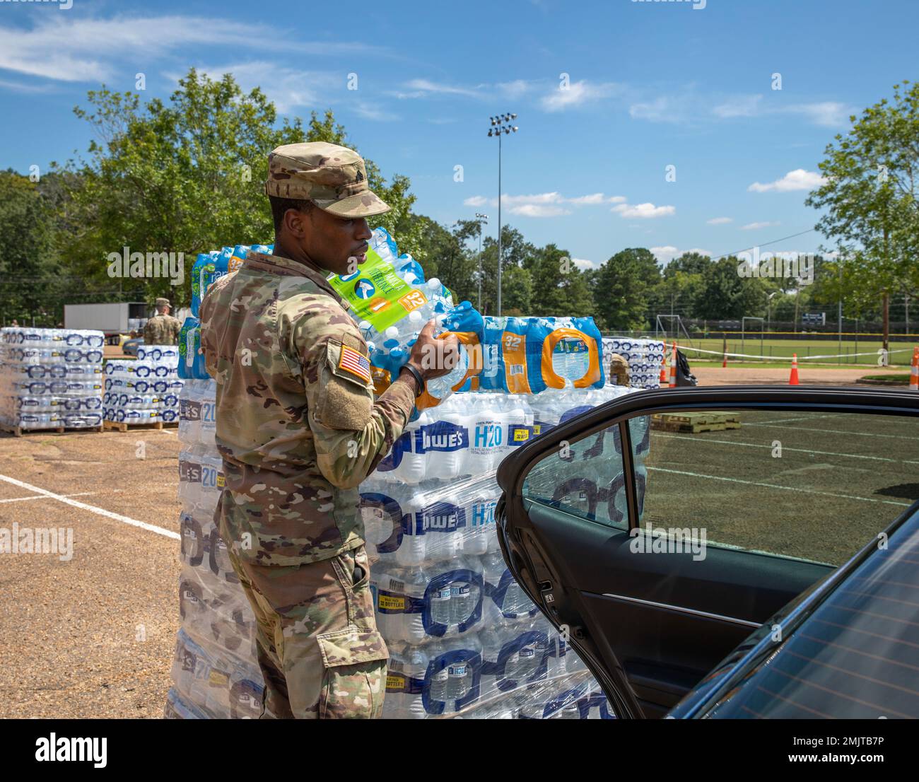 Un soldat avec un commandement de 66th troupes, la Garde nationale de l'armée du Mississippi, met de l'eau dans le siège arrière de la voiture d'une personne au stade Smith-Wills à Jackson, Mississippi, le 1 septembre 2022. Près de 600 gardes nationaux du Mississippi ont été établis sur sept sites de Jackson pour permettre aux résidents de recueillir de l'eau embouteillée et de l'eau non potable des camions d'eau pour aider à soulager certains effets de la crise de l'eau de Jackson. (É.-U. Photos de la Garde nationale de l'armée par le sergent d'état-major. Connie Jones) Banque D'Images