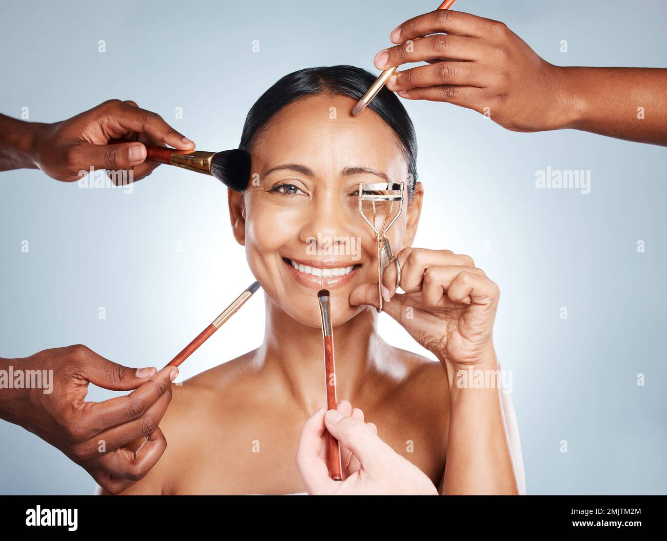 Portrait, vieille femme et outils de maquillage pour le soin de la peau, sourire et relooking sur fond gris studio. Femme mature, personne âgée ou femme avec des brosses Banque D'Images