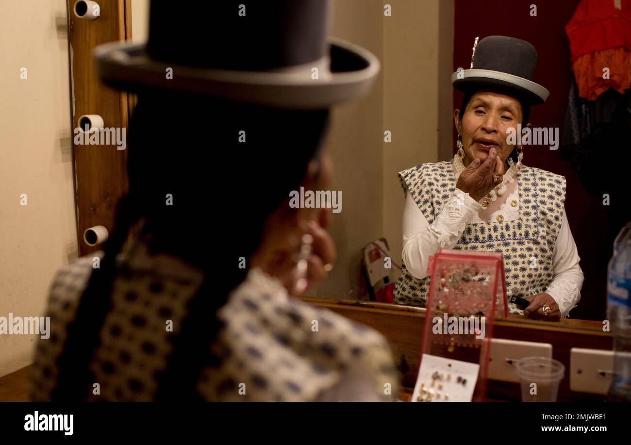 In this April 30, 2019 photo, actress Maria Luque, of the "Kory Warmis," or Women of Gold theater group that recount stories of gender-based violence, applies lip gloss in preparation for her performance at the Municipal Theater, in La Paz, Bolivia. Luque, who is one of 22 indigenous women who launched the theater group, said she was so brutally beaten by the father of her four children that she was left partly paralyzed. (AP Photo/Juan Karita) Banque D'Images