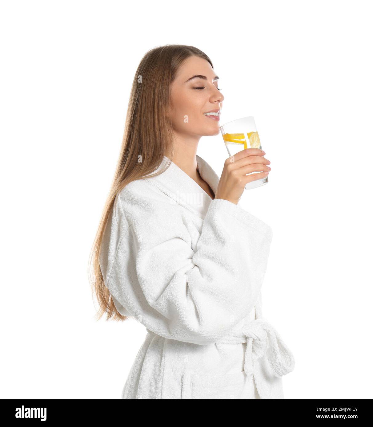 Jeune femme buvant de l'eau de citron sur fond blanc Banque D'Images