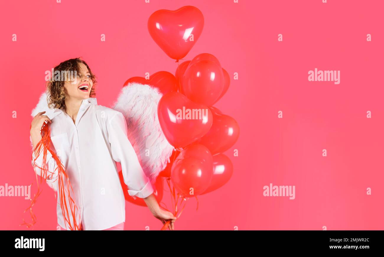 Bonne Saint Valentin. Sexy femme dans les ailes d'ange avec des ballons rouges de coeur. 14 février. Cupidon mignon. Banque D'Images