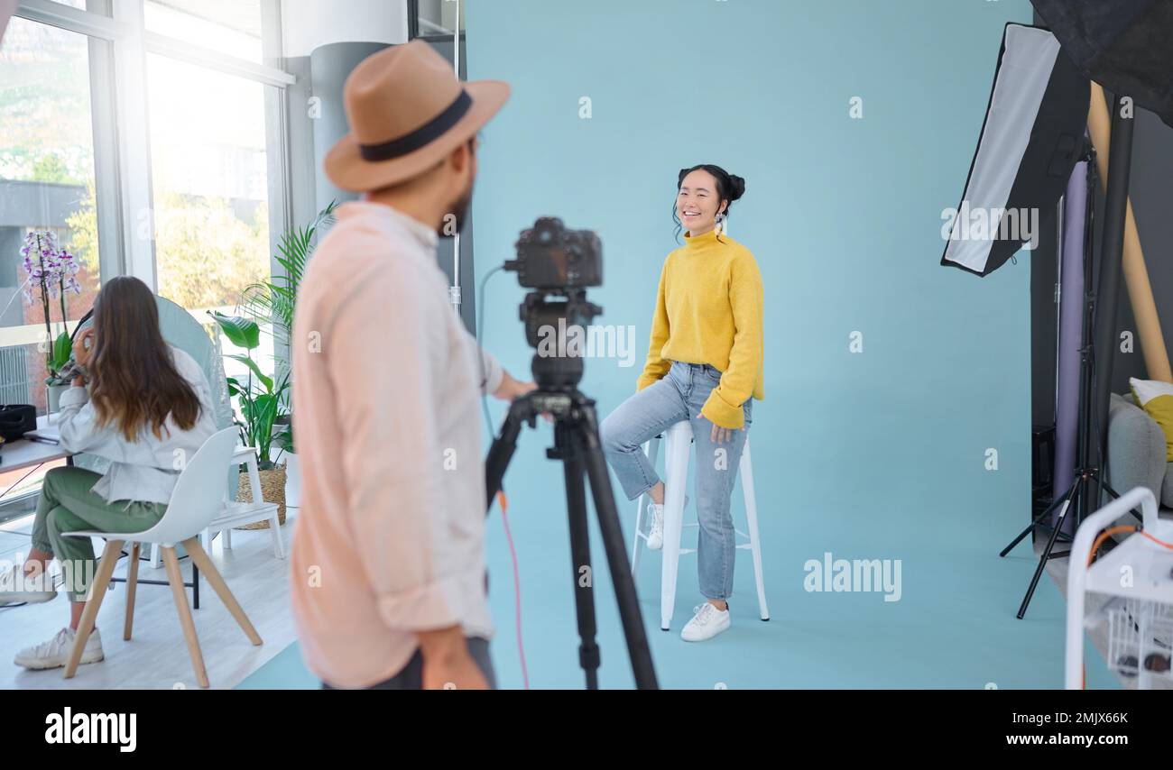 Photographe, photographe et femme modèle en studio pour professionnel, photo et pose sur fond de mur. Photographie, magazine et homme prenant des photos de Banque D'Images