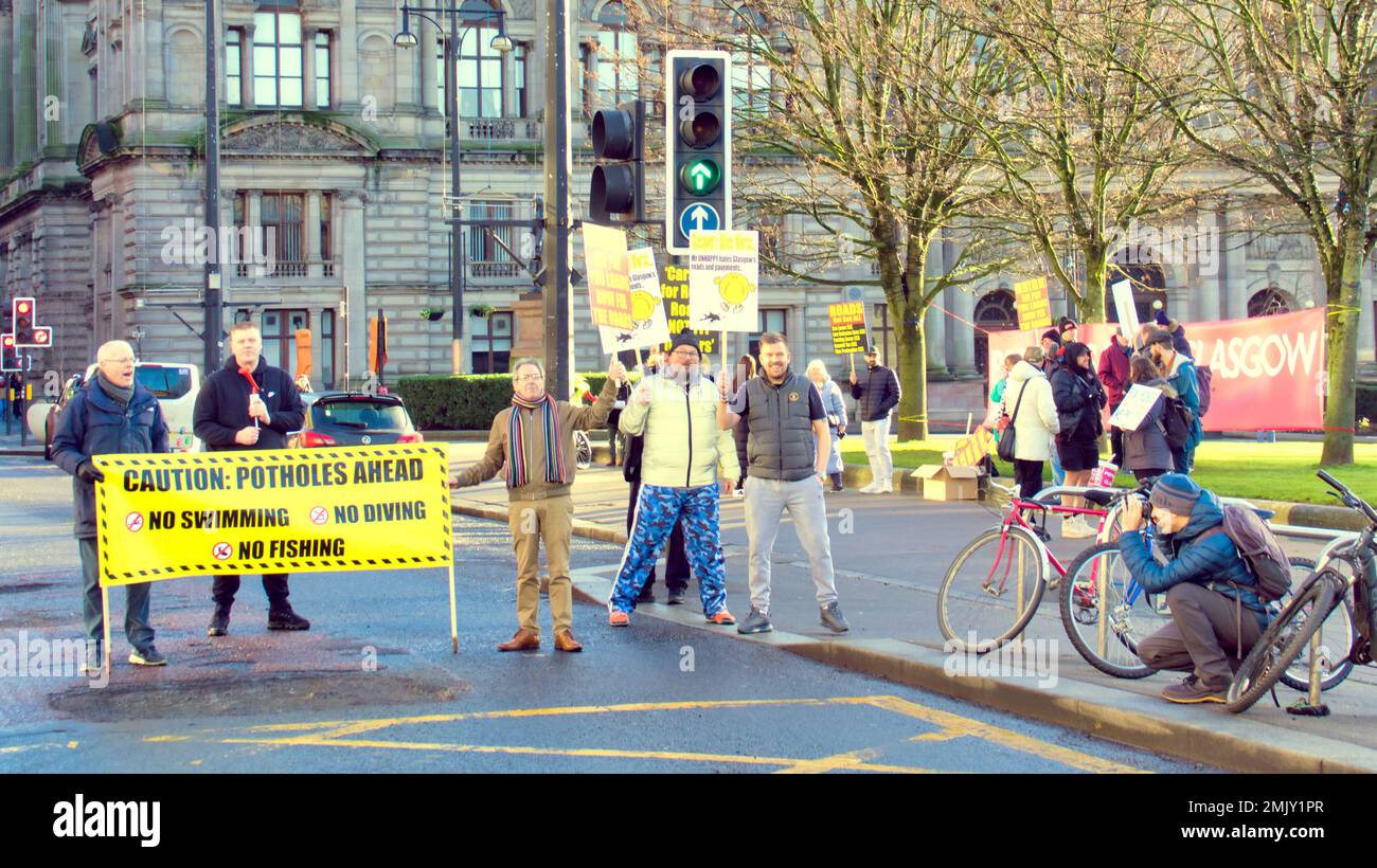 Glasgow, Écosse, Royaume-Uni 28th janvier 2023. Une grande foule de manifestants brandiés d'une bannière financée par la foule a reçu l'approbation des automobilistes qui se sont présentés sur le côté de la route avec un grand nid-de-poule lors de la manifestation de potholes devant le siège du conseil, sur la place george. Crédit Gerard Ferry/Alay Live News Banque D'Images