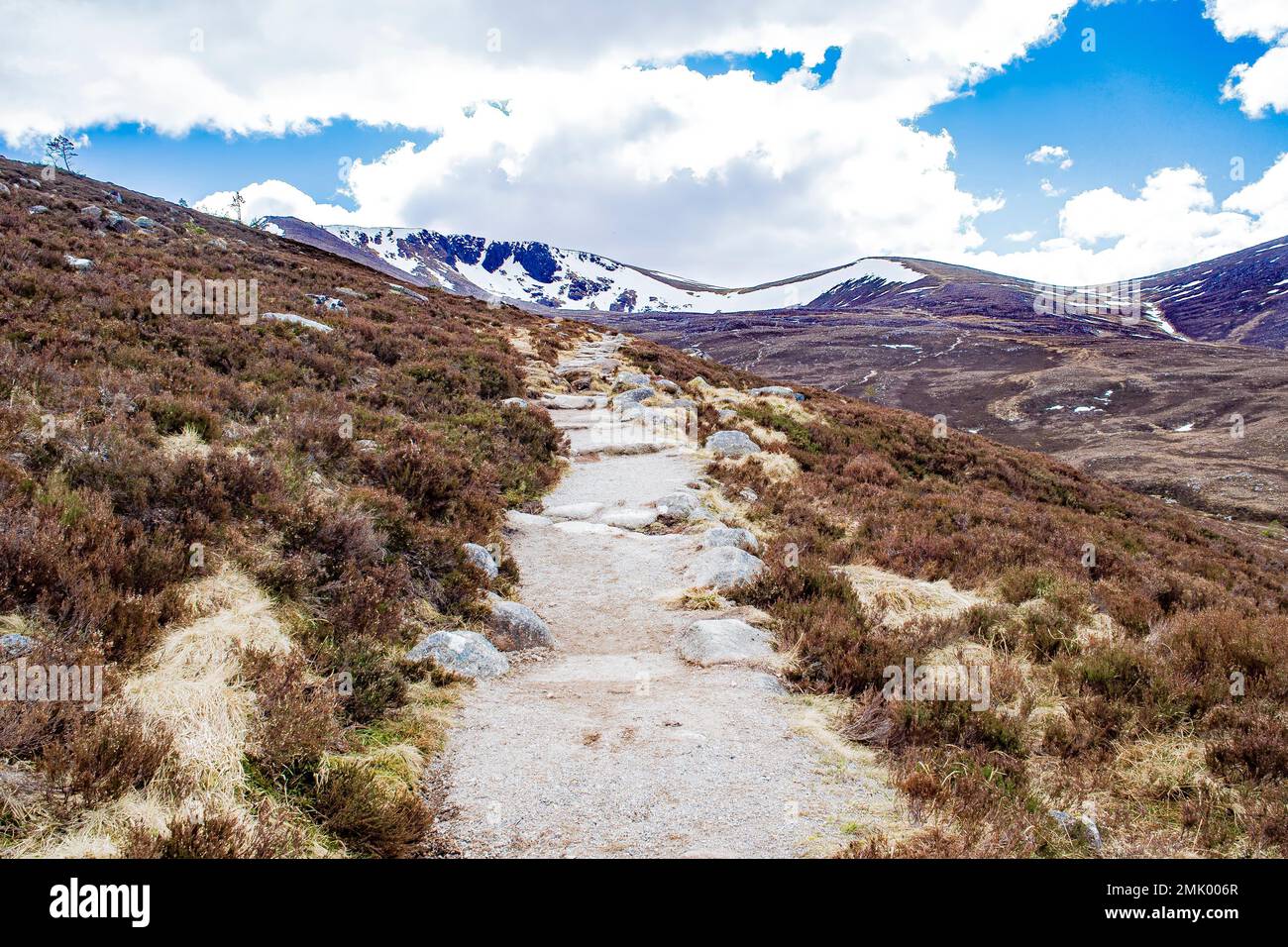 Sentier de randonnée droit, parc national de Cairngorms, Highlands écossais, Écosse, zone populaire de randonnée et de ski. Sommets enneigés, ciel bleu, rochers. Banque D'Images