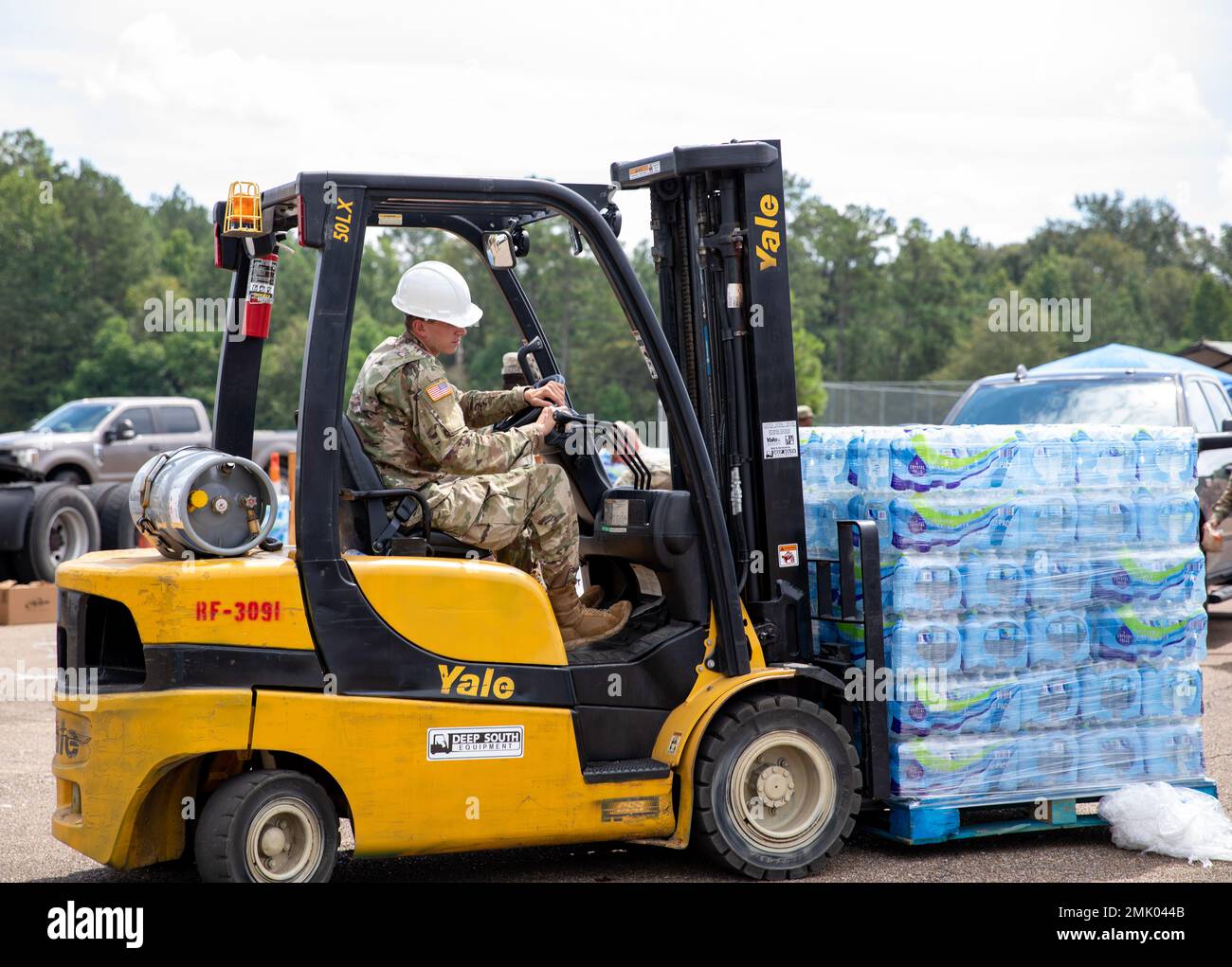 Un soldat, commandant de 66th troupes, de la Garde nationale de l'armée du Mississippi, distribue de l'eau avec un chariot élévateur à l'école moyenne Thomas Cardozo à Jackson, Mississippi, le 2 septembre 2022. Près de 600 gardes nationaux du Mississippi ont été établis sur sept sites à travers Jackson pour permettre aux gens de recueillir de l'eau en bouteille, de l'assainisseur pour les mains et de l'eau non potable dans des camions de buffles d'eau. Banque D'Images