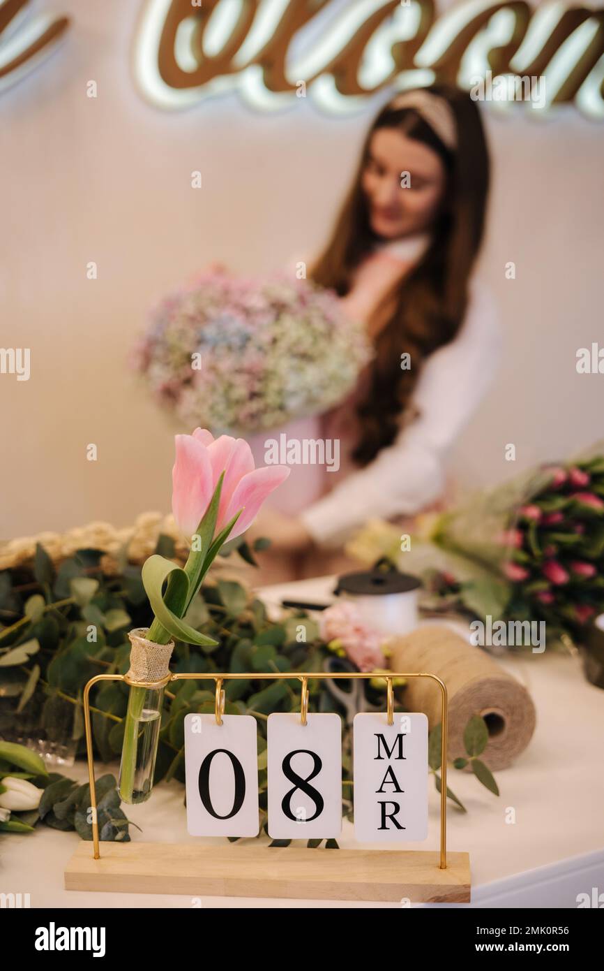 Gros plan de femme faire le bouquet de printemps. Le fleuriste féminin présente un magnifique bouquet de fleurs printanières dans un emballage en papier. Belle composition florale de Banque D'Images