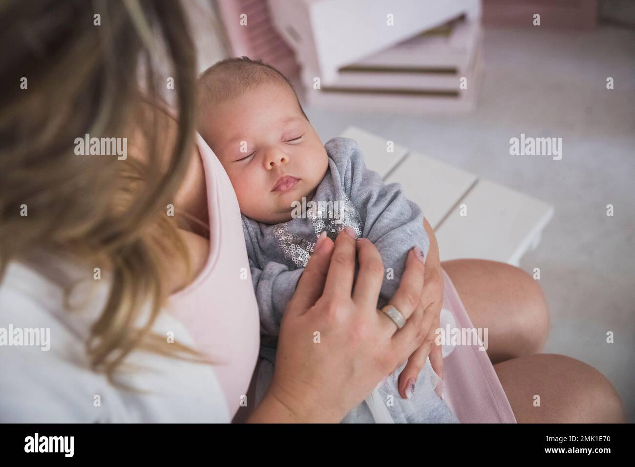 la mère tient la charmante fille de nouveau-né qui dormait Banque D'Images