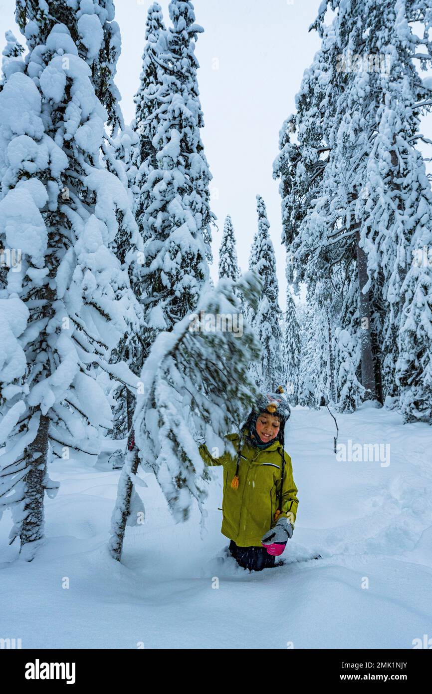 Garçon gai s'amuser dans la forêt enneigée, ISO Syote, Ostrobothnia du Nord, Laponie, Finlande Banque D'Images