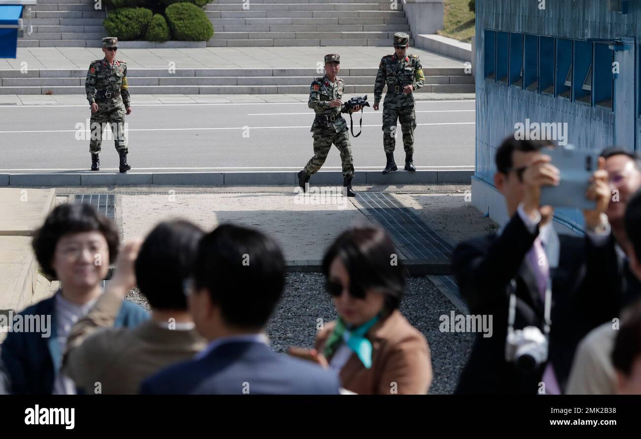 North Korean soldiers walk near the military demarcation line as South Korean visitors take their souvenir photos, seen during a press tour at the border village of Panmunjom in the Demilitarized Zone, South Korea, Wednesday, May 1, 2019. South Korea on Wednesday resumed the southern side of Panmunjom tour to tourists. (AP Photo/Lee Jin-man) Banque D'Images