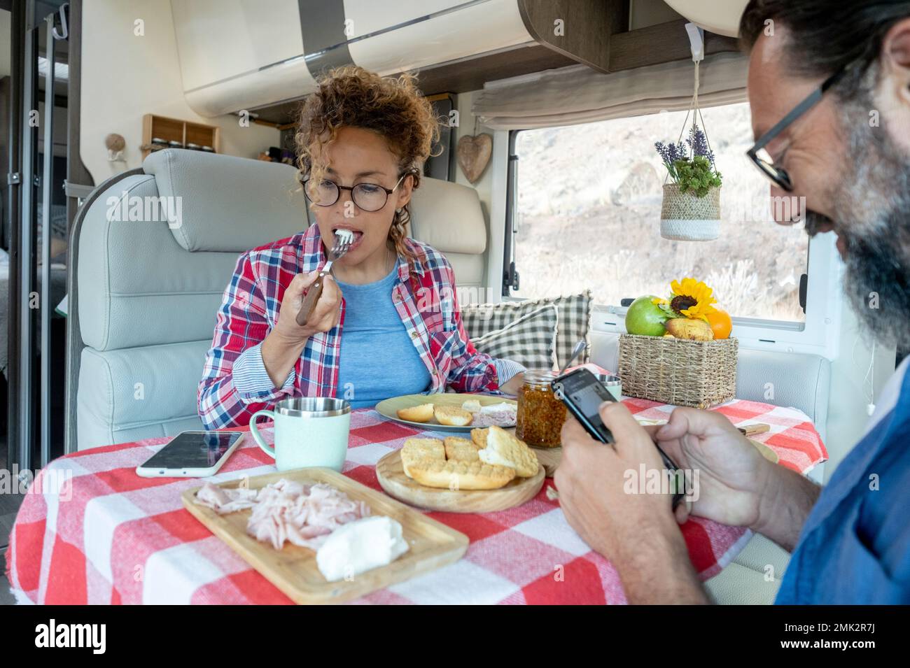 Homme et femme mangeant le déjeuner ensemble en utilisant le téléphone sans parler les uns les autres. Couple de voyageurs modernes utilisant la connexion mobile d'appareil d'itinérance sur le Banque D'Images