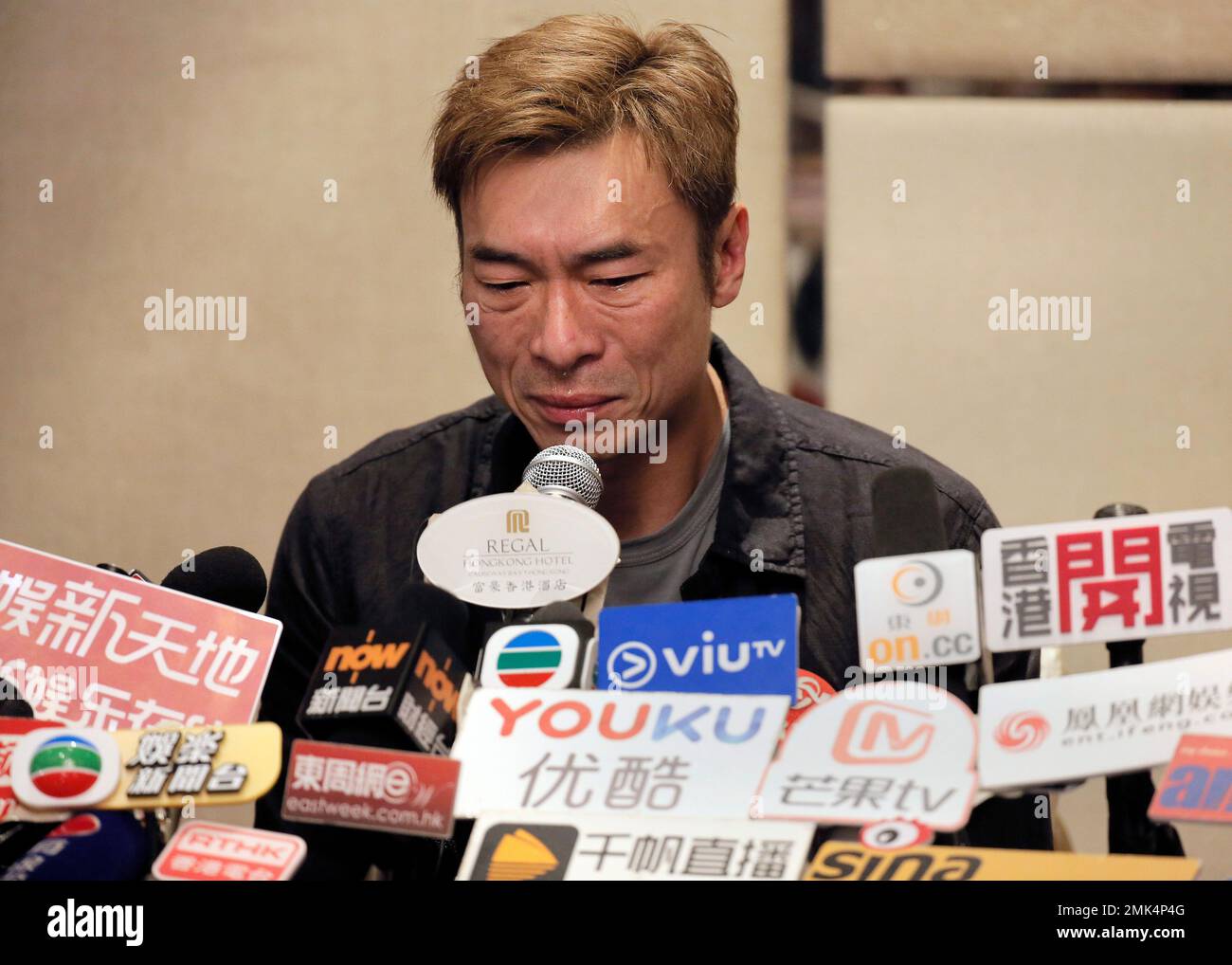 Hong Kong singer Andy Hui reacts during a press conference about his affair in Hong Kong, Tuesday, April 16, 2019. Hong Kong's Apple Daily newspaper published video that purported to show Andy Hui being intimate in a taxi with another Hong actress, decades younger than him, Jacqueline Wong. (AP Photo/Vincent Yu) Banque D'Images