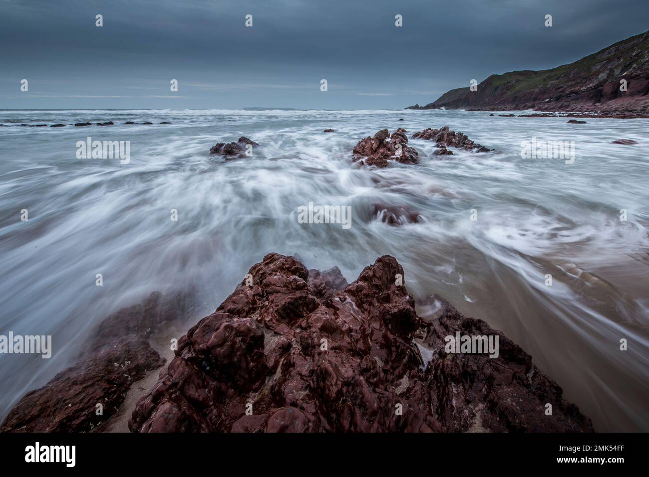 Plage de West Dale, Pembrokeshire. Marée entrante sur les rochers, exposition lente pour l'eau en mouvement et les vagues. Banque D'Images