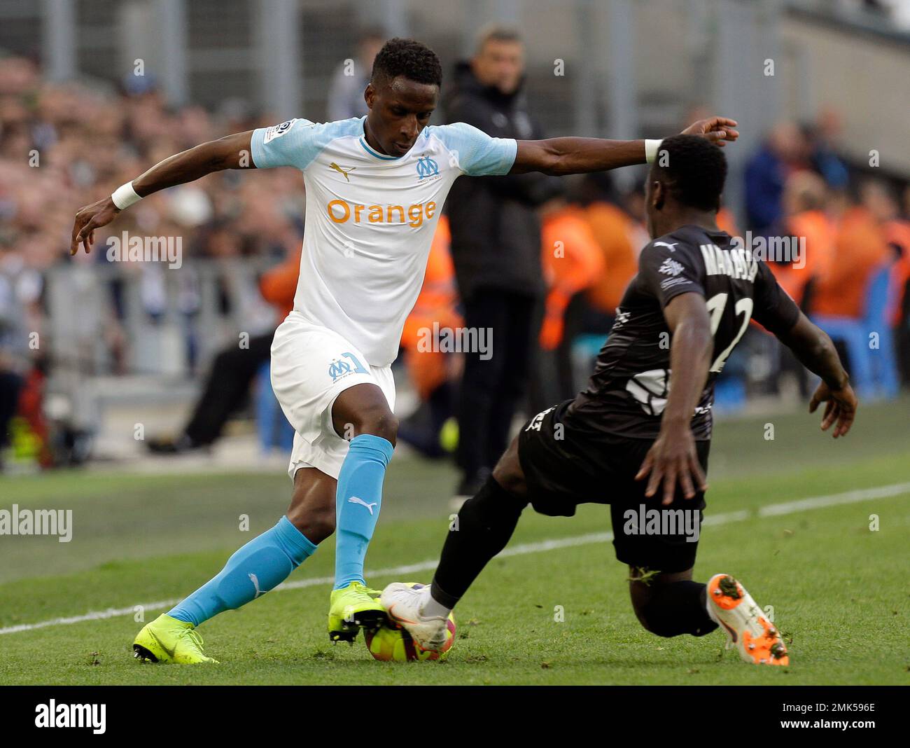 Marseille's Bouna Sarr, left, challenges for the ball with Nimes' Faitout Maoussa, during the League One soccer match between Marseille and Nimes, at the Velodrome Stadium, in Marseille, southern France, Saturday, April 13, 2019. (AP Photo/Claude Paris) Banque D'Images