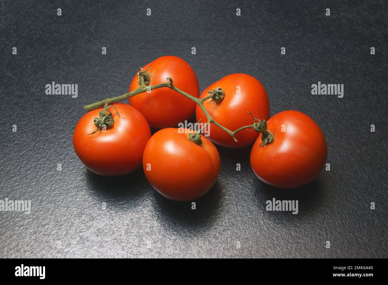 branche de tomates sur une table sombre Banque D'Images