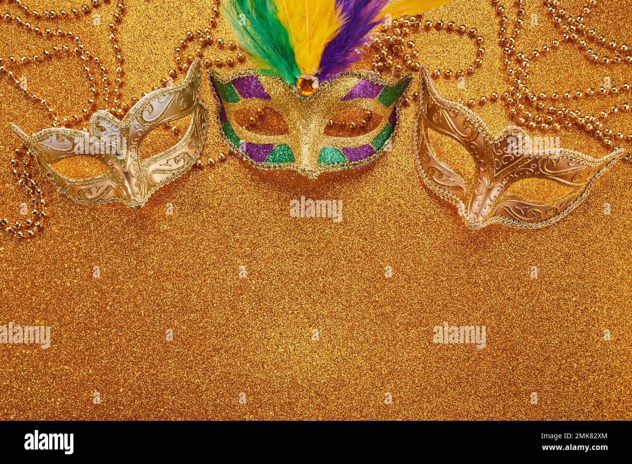 Mardi gras ou masque de carnaval avec perles sur fond doré brillant. Masque vénitien. Banque D'Images