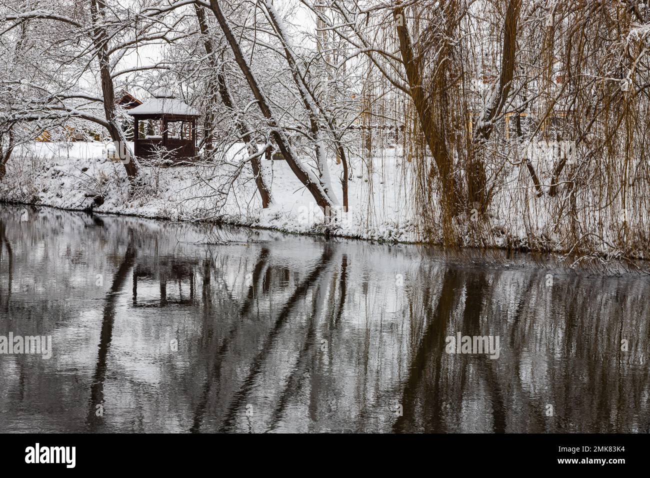 Un petit belvédère en bois dans les profondeurs d'une forêt d'hiver près d'un ruisseau de montagne froid et noyés marchent le long de lui, grimpant d'une vallée forestière. Banque D'Images