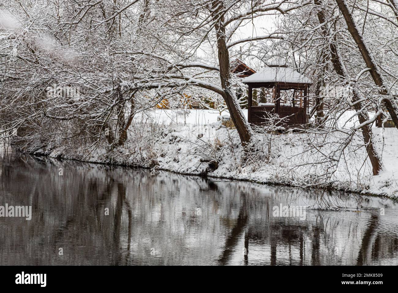 Un petit belvédère en bois dans les profondeurs d'une forêt d'hiver près d'un ruisseau de montagne froid et noyés marchent le long de lui, grimpant d'une vallée forestière. Banque D'Images