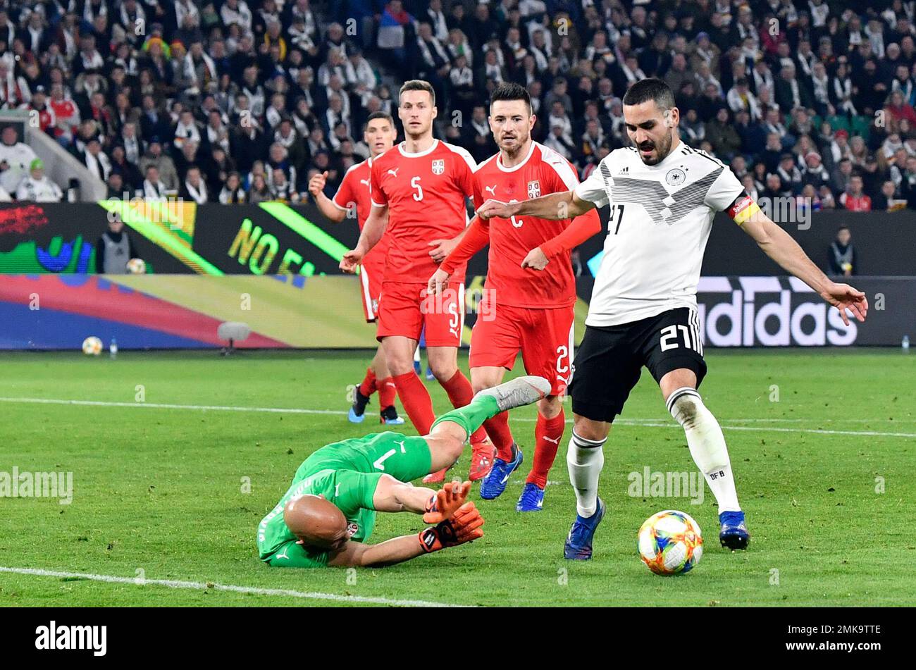 Serbia goalkeeper Marko Dmitrovic, left, makes a save in front of Germany's Ilkay Gundogan during a international friendly soccer match between Germany and Serbia at the Volkswagen Arena stadium in Wolfsburg, Germany, Wednesday, March 20, 2019. (AP Photo/Martin Meissner) Banque D'Images