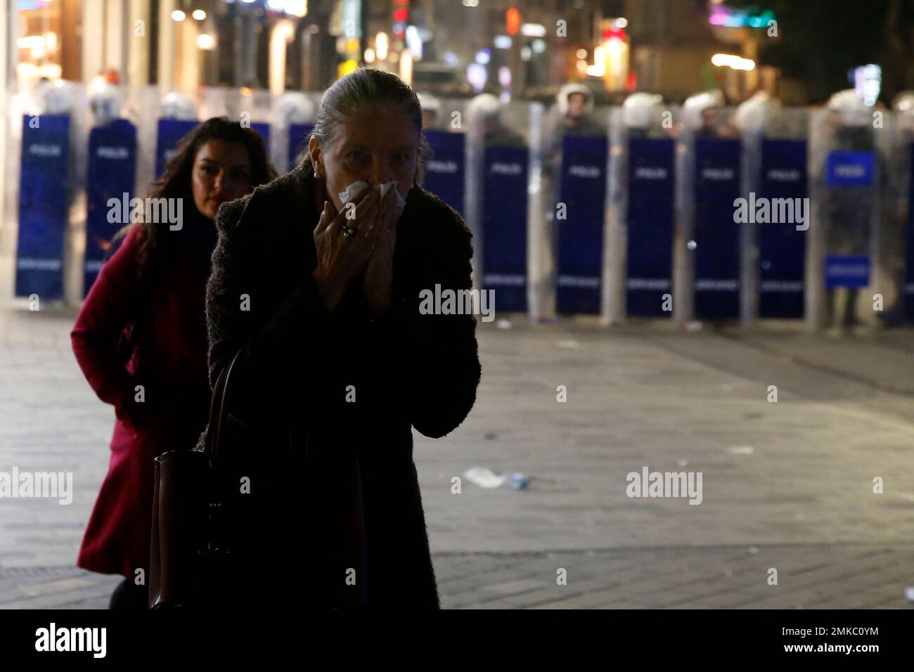 A woman holds her nose after Turkish police fired tear gas at Istiklal, the main shopping street, in Istanbul, during the International Women's Day, Friday, March 8, 2019. The day has been sponsored by the United Nations since 1975 as millions around the world are demanding equality amid a persistent salary gap, violence and widespread inequality. (AP Photo/Lefteris Pitarakis) Banque D'Images