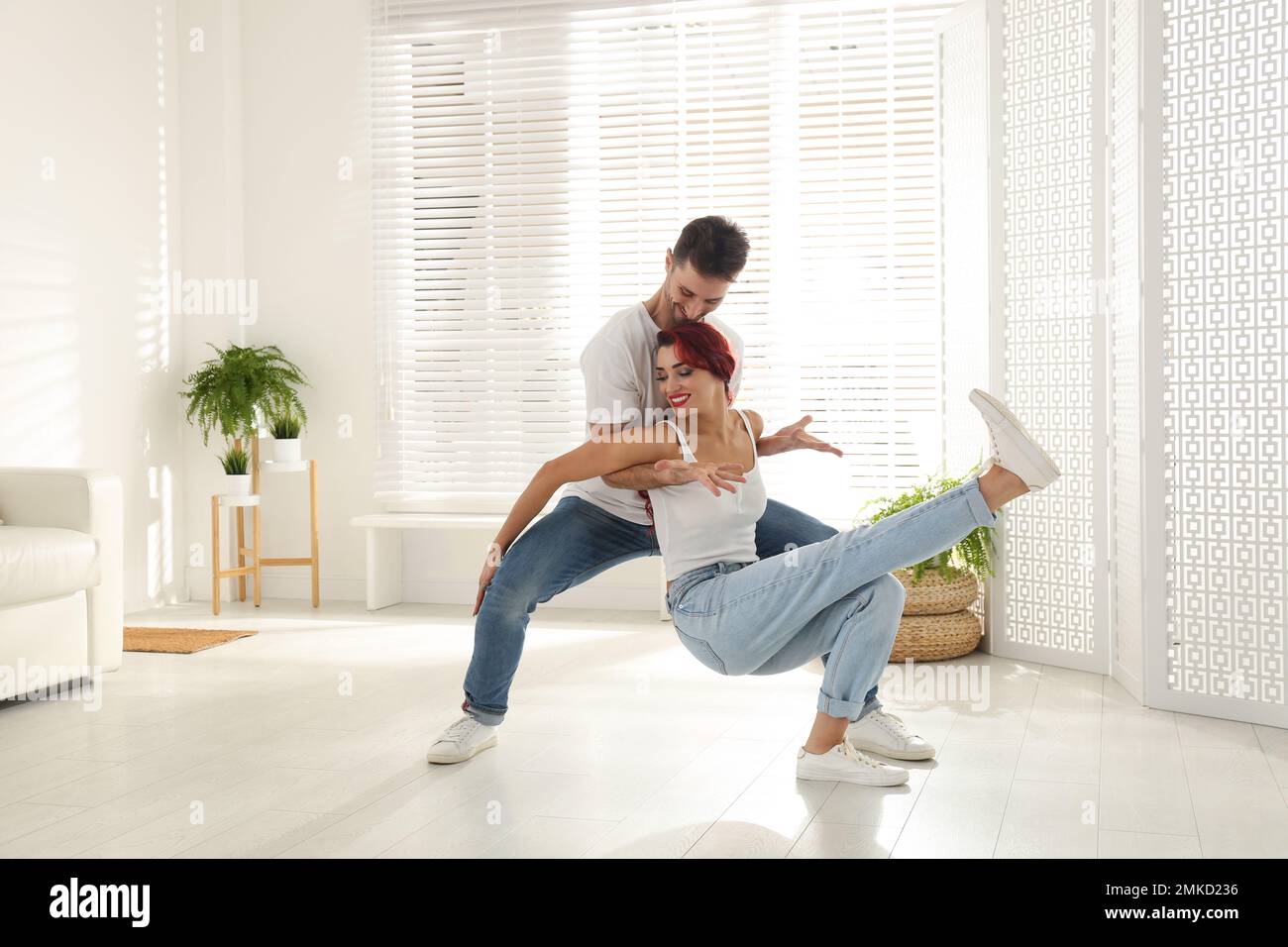 Beau jeune couple dansant dans la salle de séjour Banque D'Images