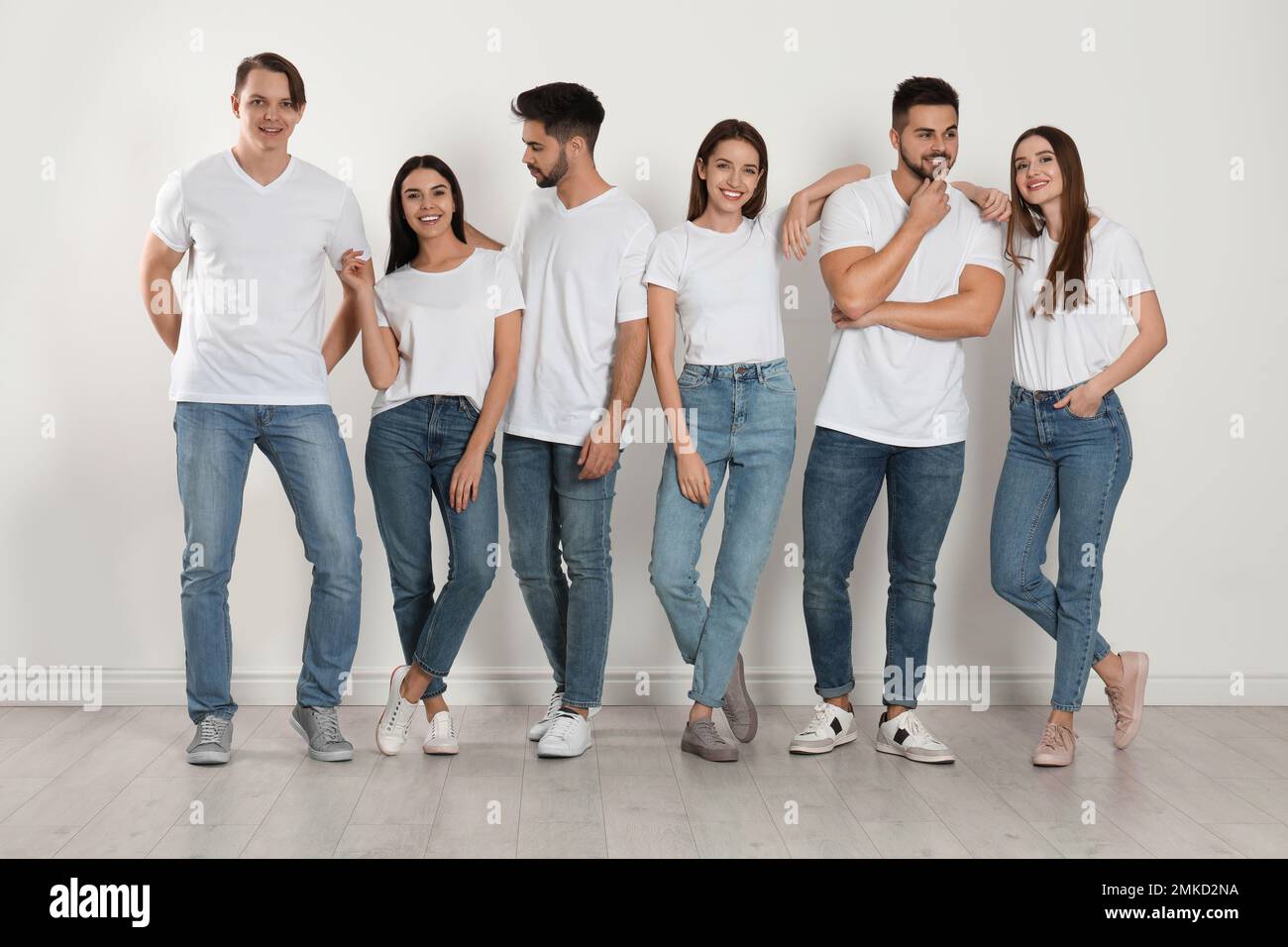 Groupe de jeunes dans un Jean élégant près du mur blanc Photo Stock - Alamy