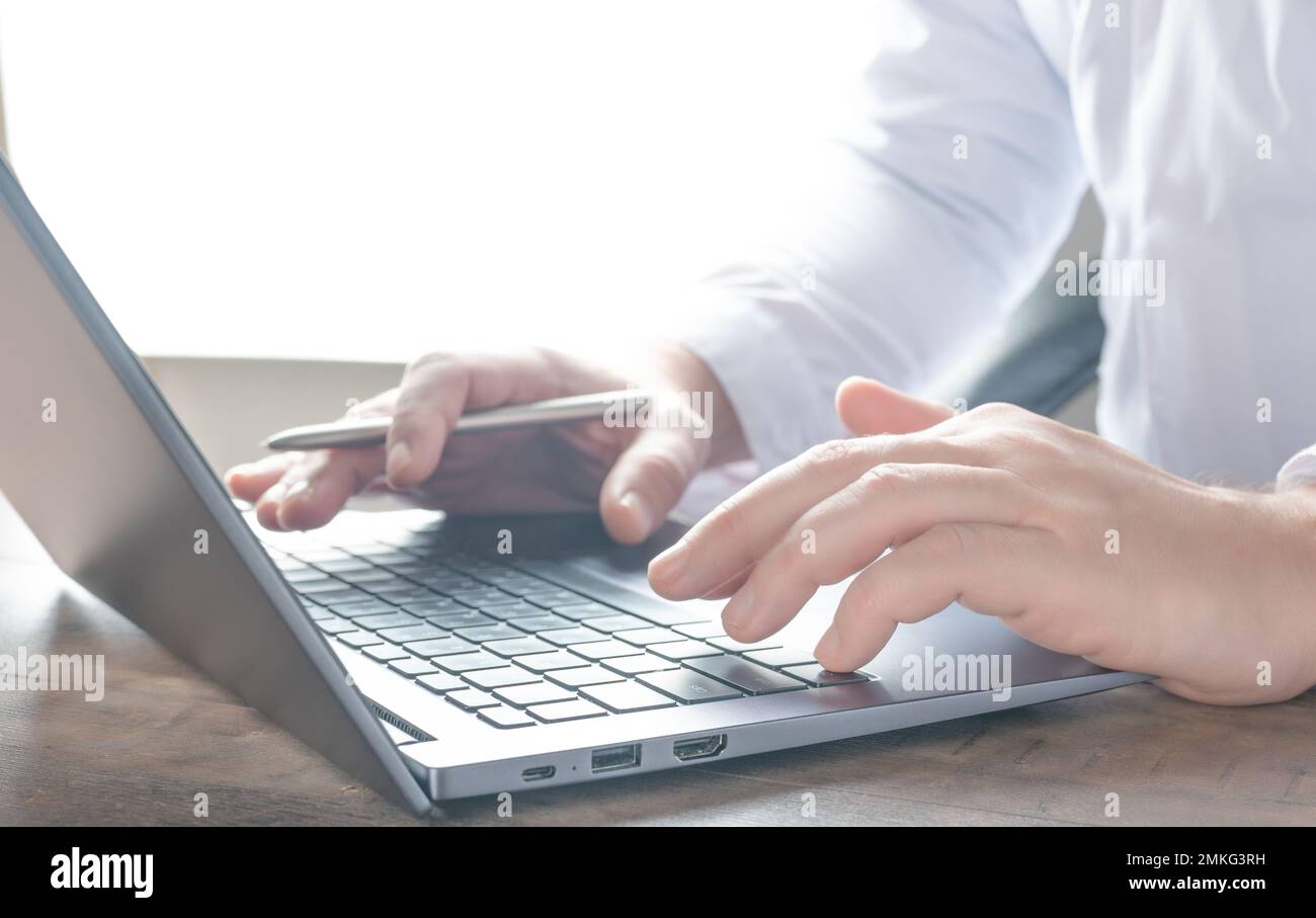 Gros plan homme d'affaires tapant sur un ordinateur portable sur le lieu de travail. Gros plan homme d'affaires mains travail ordinateur portable de recherche ou de saisie de message texte pour le nouveau projet Banque D'Images
