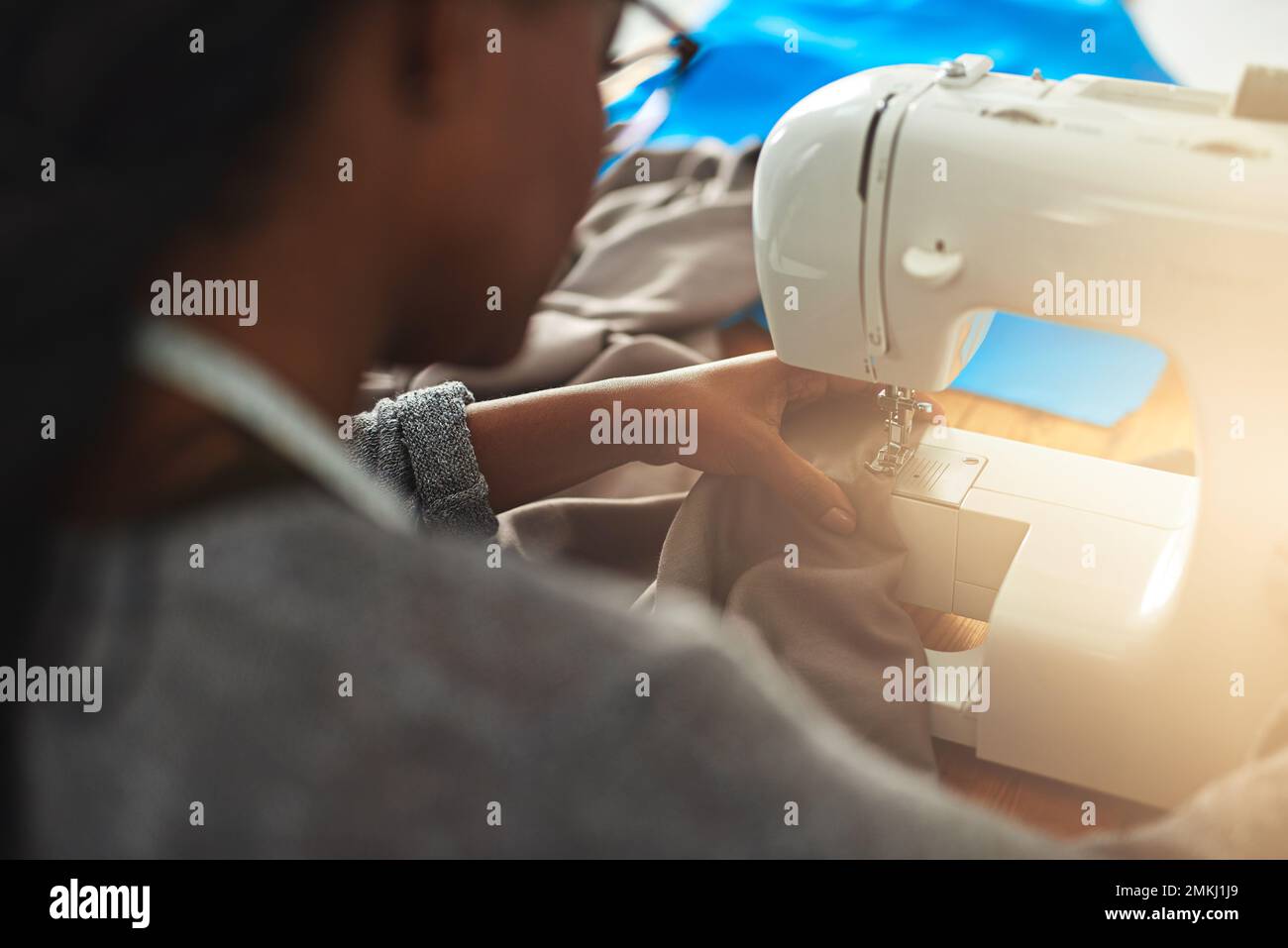 Les tissus ne font pas de robes exquises, ses points de suture. une jeune couturière utilisant une machine à coudre dans son atelier. Banque D'Images