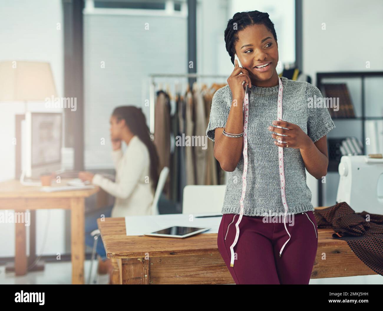 Je vis, mange et respire la mode. une designer parlant au téléphone avec sa collègue a été floue en arrière-plan. Banque D'Images