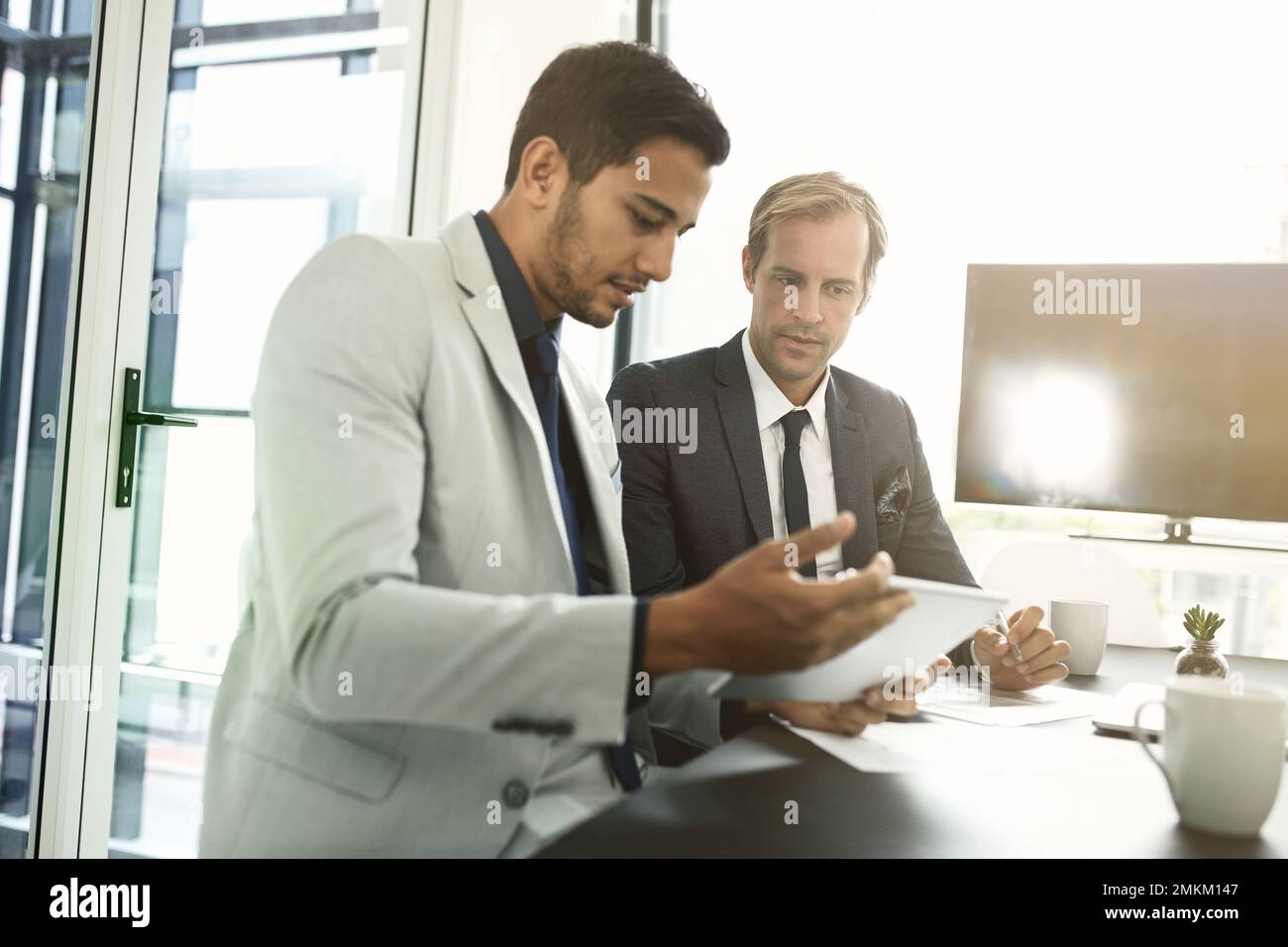 Leur succès repose sur le travail d'équipe. deux hommes d'affaires ayant une discussion dans un bureau. Banque D'Images
