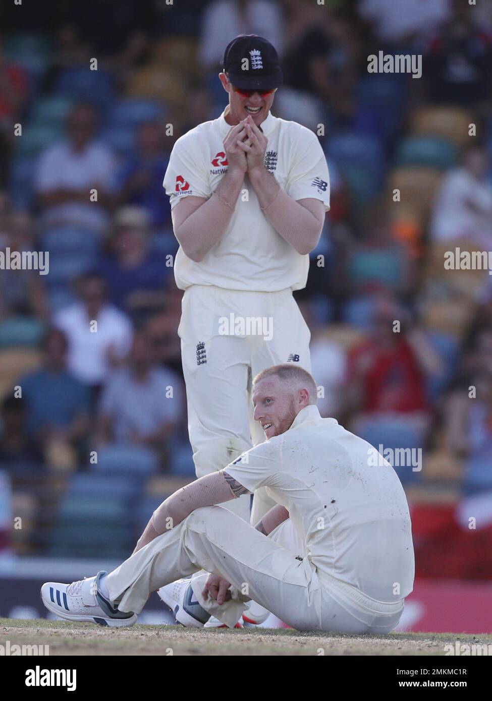 England's Ben Stokes sits on the pitch celebrating with England's Keaton Jennings the dismissal of West Indies' John Campbell during day two of the first cricket Test match at the Kensington Oval in Bridgetown, Barbados, Thursday, Jan. 24, 2019. (AP Photo/Ricardo Mazalan) Banque D'Images
