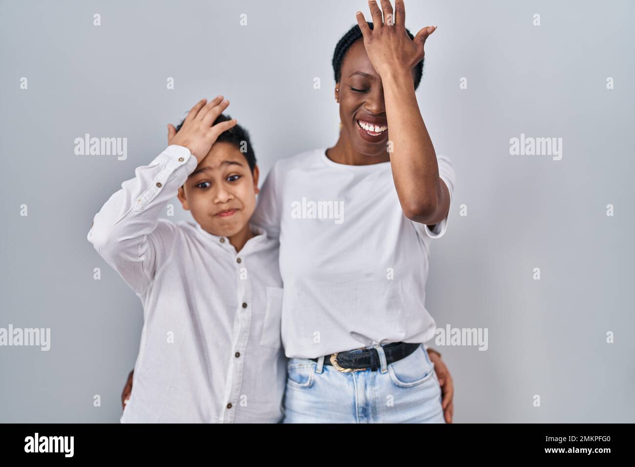 Jeune mère et fils debout ensemble sur fond blanc surpris de main sur la tête pour erreur, se souvenir erreur. oubli, mauvais concept de mémoire. Banque D'Images Jeune mère et fils debout ensemble sur fond blanc surpris de main sur la tête pour erreur, se souvenir erreur. oubli, mauvais concept de mémoire. Banque D'Images