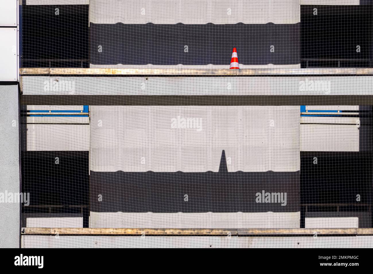 Rénovation de la façade de la maison à Berlin. Un cône de construction rouge et blanc sur un échafaudage projette son ombre sous la forme d'un ECG sur un mur du sol en dessous. Banque D'Images