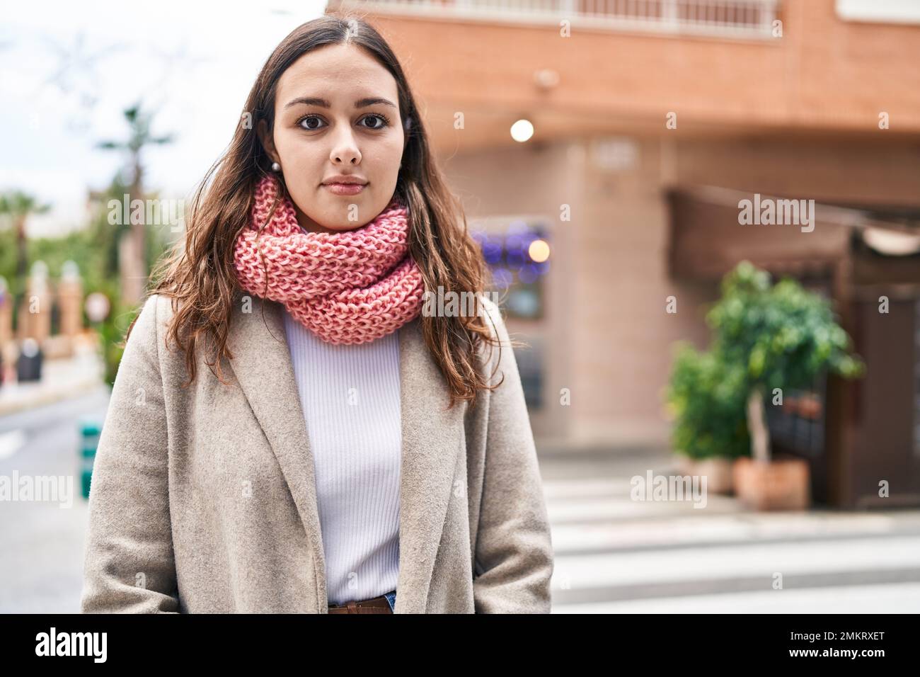 Jeune belle femme hispanique debout avec expression décontractée portant  une écharpe dans la rue Photo Stock - Alamy