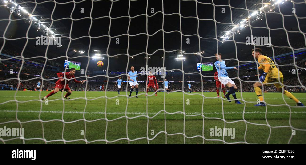 Liverpool's Roberto Firmino, left, heads the ball and scores his sides 1st goal during their English Premier League soccer match between Manchester City and Liverpool at the Ethiad stadium, Manchester England, Thursday, Jan. 3, 2019. City won the game 2-1. (AP Photo/Jon Super) Banque D'Images