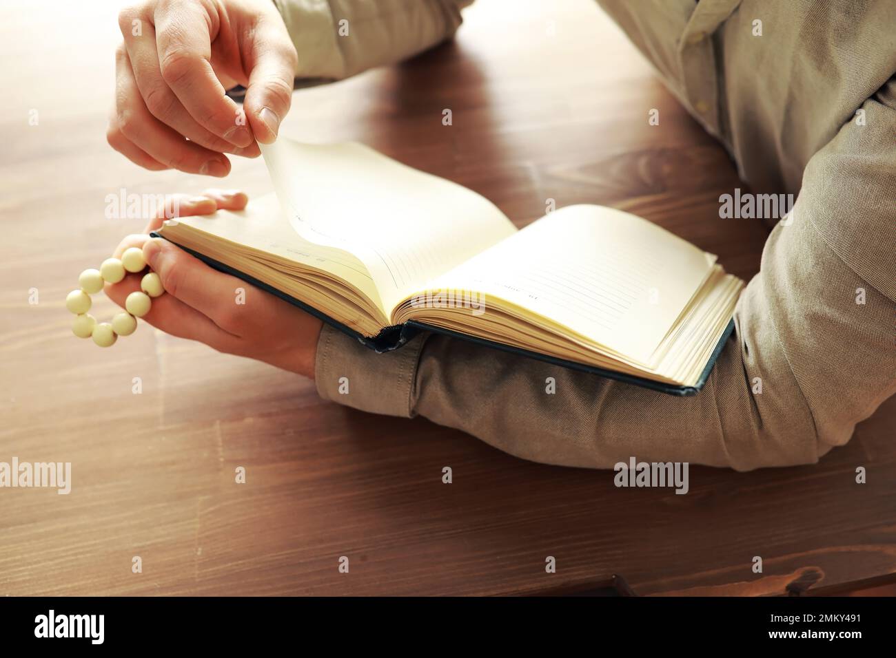 Lecture de la littérature religieuse. Livre ouvert. L'homme lit le coran biblique. Banque D'Images